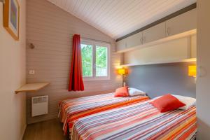 a bedroom with a bed and a window at Lagrange Grand Bleu Vacances – Résidence Port Lalande in Castelmoron-sur-Lot