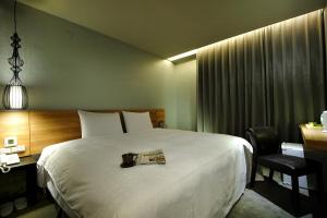 una camera d'albergo con un letto e un quotidiano di Forward Suites II a Taipei
