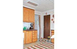 eine Küche mit Holzschränken und einer Arbeitsplatte in der Unterkunft Beautiful Home In Tcksfors With 2 Bedrooms in Navarsviken