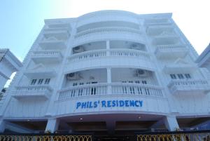 un edificio blanco con un signo de reserva de pastillas en él en Phils' Residency & Banquets, en Kochi