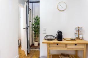 une chambre avec une table et une horloge sur le mur dans l'établissement LovelyStay - Traditional Alfama View, à Lisbonne