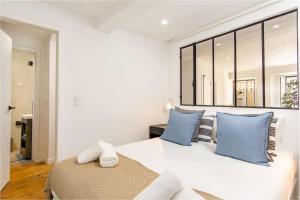 - une chambre blanche avec un grand lit et des oreillers bleus dans l'établissement LovelyStay - Traditional Alfama View, à Lisbonne
