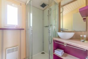 ein Bad mit einem Waschbecken und einer Glasdusche in der Unterkunft Lagrange Grand Bleu Vacances – Résidence Port Lalande in Castelmoron-sur-Lot
