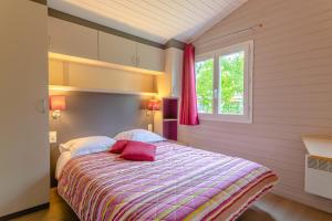 a bedroom with a bed with a colorful blanket at Lagrange Grand Bleu Vacances – Résidence Port Lalande in Castelmoron-sur-Lot