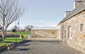 a house with a glass facade and a stone wall at Amazing Home In Kerbors With 2 Bedrooms in Kerbors