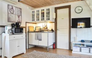 una cocina con armarios blancos y un reloj en la pared en Lovely Home In Strngns With Kitchen en Strängnäs