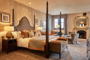 a bedroom with a large bed and a fireplace at Stanbrook Abbey Hotel, Worcester in Worcester