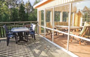 a screened in porch with a table and chairs at Stunning Home In Lidhult With Lake View in Lidhult
