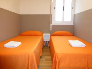 two beds in a room with orange sheets at Rentalmar Delfos Playa in Salou