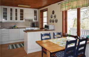 a kitchen with a wooden table and a table and chairs at Three-Bedroom Holiday Home In Valdemarsvik in Valdemarsvik