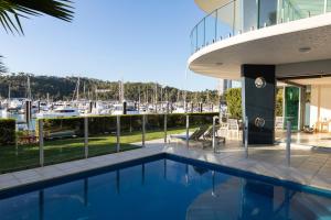 a house with a swimming pool and a marina at Pavillion 17 - Waterfront Spacious 4 Bedroom With Own Inground Pool And Golf Buggy in Hamilton Island