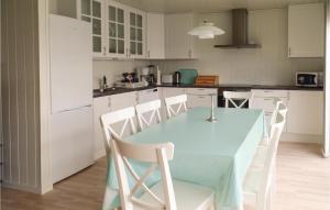 uma cozinha com uma mesa azul e armários brancos em Stunning Apartment In Lindesnes With Kitchen em Gare