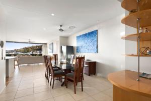 uma cozinha e sala de jantar com mesa e cadeiras em Pavillion 17 - Waterfront Spacious 4 Bedroom With Own Inground Pool And Golf Buggy em Hamilton Island