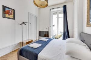 リヨンにあるNOCNOC - L'Escapadeの白いベッドルーム(ベッド1台、テレビ付)