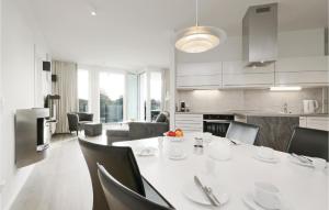 una cucina e una sala da pranzo con tavolo e sedie bianchi di Beautiful Apartment In Lbeck Travemnde With Sauna a Travemünde