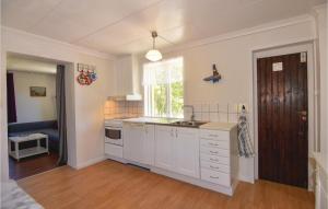 a kitchen with white cabinets and a sink and a window at One-Bedroom Holiday Home In Hunnebostrand in Hunnebostrand