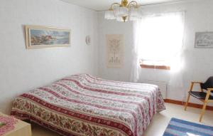 a bedroom with a bed with a blanket on it at Lovely Home In Mattmar With Kitchen in Arvesund