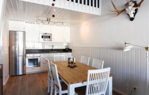 a kitchen with a wooden table and white chairs at Awesome Home In Brans With Wifi in Branäs