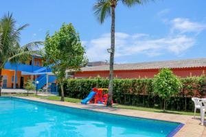 a swimming pool with a playground next to a building at Vila do Tombo in Guarujá