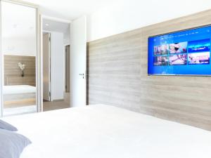 a bedroom with a white bed and a tv on a wall at Großes Apartment im Zentrum von Dresden, 2 Schlafzimmer, 2 Bäder, Balkon in Dresden