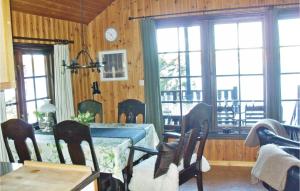 a dining room with a table and chairs and windows at Sjöstugan in Pålsmåla