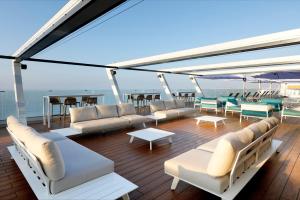 una terraza en un crucero con sillas y mesas en Hotel Benalma Costa del Sol, en Benalmádena