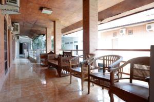 una sala da pranzo con tavoli e sedie in legno di RedDoorz Plus at Hotel Srikandi Kendari a Kendari