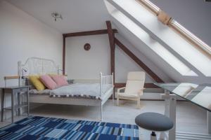 a attic bedroom with a bed and a glass table at CITYSTAY Dekerta Apartment in Gdańsk