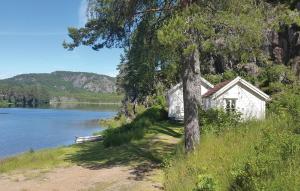 a white house on the shore of a lake at Stunning Home In Hornnes With House Sea View in Hornnes