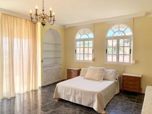 阿爾穆涅卡爾的住宿－CHALET CON PISCINAS Y VISTAS DE ENSUEÑO，一间卧室设有一张床和两个窗户。