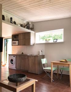 a kitchen with wooden cabinets and a table and a microwave at Namelis Palangoje in Palanga