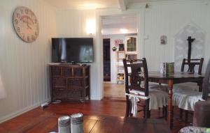 sala de estar con TV, mesa y reloj en Stunning Home In Hornnes With House Sea View en Hornnes