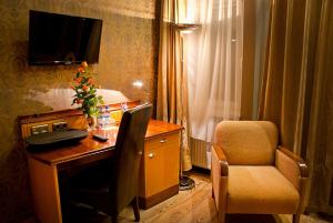 ゴジュフ・ヴィエルコポルスキにあるHotel MCM Plusのデスク、椅子、テレビが備わるホテルルームです。