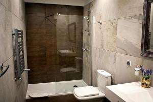 een badkamer met een douche, een toilet en een wastafel bij Hotel MCM Plus in Gorzów Wielkopolski