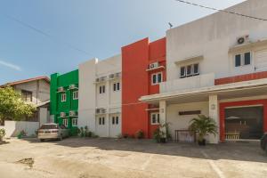 a row of colorful buildings with a car parked in front at RedDoorz Syariah @ Panglima Nyak Makam Aceh in Banda Aceh
