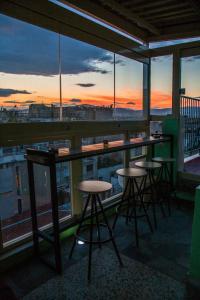 a bar with stools on a balcony with a view at Safestay Athens Monastiraki in Athens