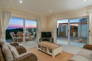 Una sala de estar con un sofá y un televisor. en Pezula Fairlead Luxury, en Knysna