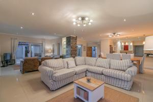 una sala de estar con un sofá y una mesa en Pezula Fairlead Luxury, en Knysna