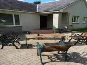 a patio with a picnic table and benches in front of a house at Tayburn House in Dunkeld