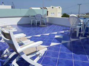a patio with chairs and tables on a roof at Pension Ptolemeos in Fira