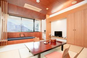 a living room with a table and a large window at Lalaca in Hakone