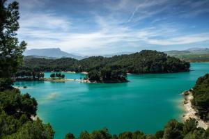 アロラにあるHostal la Molinaの青い水と木々が茂る湖の景色