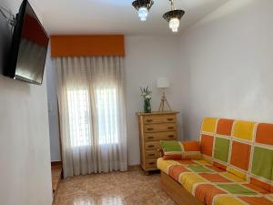 a living room with a couch and a television at Casa Rural Arenal in Torrijo de la Cañada