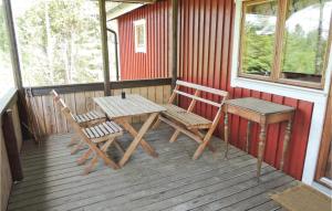 a wooden table and two chairs on a porch at Pet Friendly Home In Simlångsdalen in Älmhult