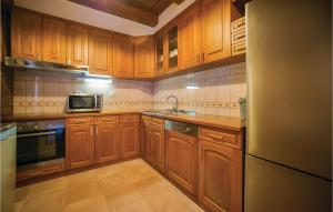 a kitchen with wooden cabinets and a sink and a microwave at 3 Bedroom Beautiful Home In Tivat in Tivat