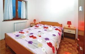 a bedroom with a bed with a floral bedspread at Lovely Apartment In Izola With Kitchen in Izola