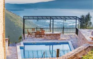 a swimming pool on a patio with a table and a table at 3 Bedroom Beautiful Home In Tivat in Tivat