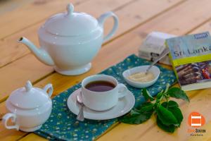 a cup of coffee and a tea pot on a table at Bunk Station in Ella