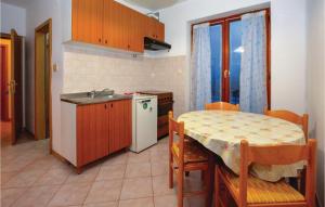 a kitchen with a table and a small kitchen with a table and chairs at Lovely Apartment In Izola With Kitchen in Izola