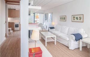 a living room with a white couch and a kitchen at Awesome Home In Burgsvik With Wifi in Burgsvik